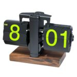 Horloge à pages flip rétro noire avec chiffres néon vert sur base en bois, vue de face sur fond blanc.