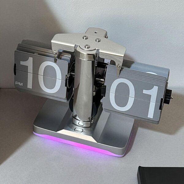 Horloge à palette rétro auto-flip argent affichant 10:01 PM avec éclairage LED violet, design mécanique moderne. Horloge à palette rétro auto-flip argent affichant 10:01 PM avec éclairage LED violet, design mécanique moderne.