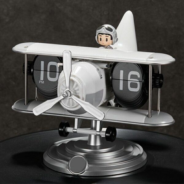 Horloge flip design avion rétro blanche avec pilote, mécanisme silencieux à feuillets, sur fond sombre. Horloge flip design avion rétro blanche avec pilote, mécanisme silencieux à feuillets, sur fond sombre.