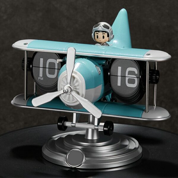 Horloge flip mécanique en forme d'avion biplan bleu, design rétro avec pilote miniature et affichage numérique. Horloge flip mécanique en forme d'avion biplan bleu, design rétro avec pilote miniature et affichage numérique.