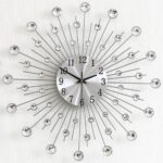 Horloge murale silencieuse diamants acryliques avec cadran métal brossé et rayons décoratifs